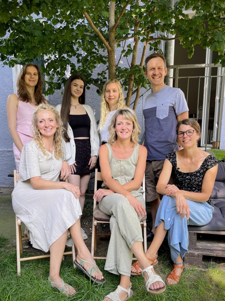 Team der WG im Garten auf Bank