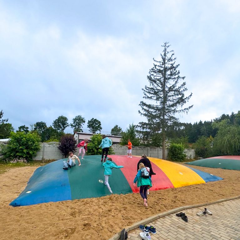 Kinder im Sandkasten und Sprungtuch