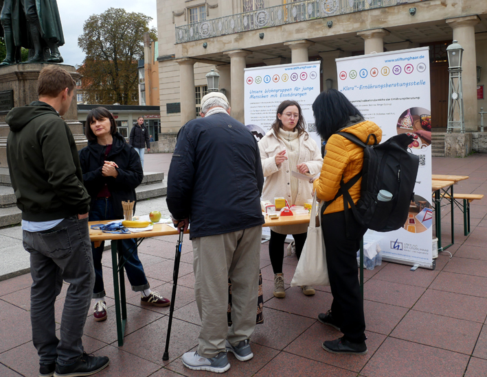 Mitarbeiterinnen und Besucher am Infostand auf dem Theaterplatz